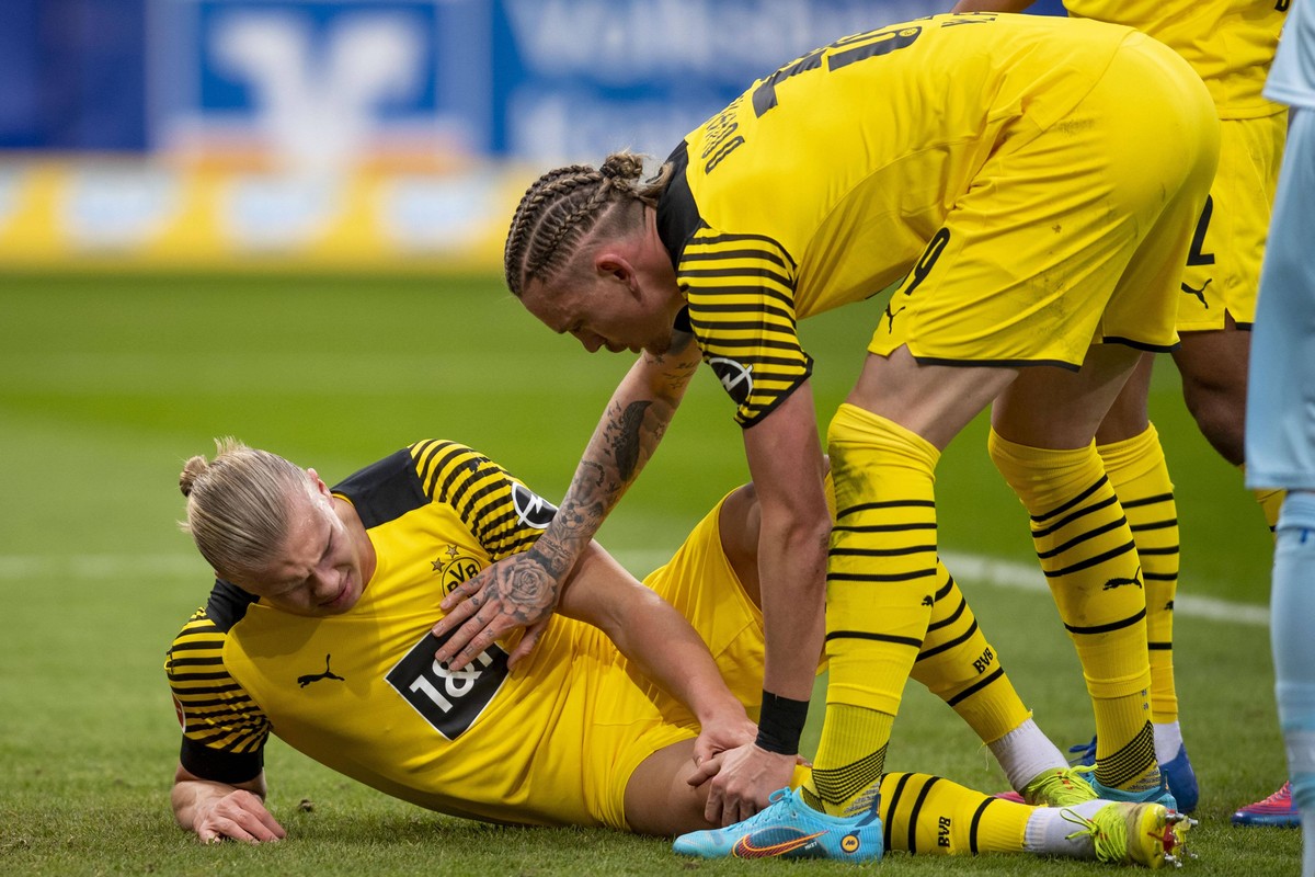 Fu�ball: 1. Bundesliga, 20. Spieltag, TSG Hoffenheim - Borussia Dortmund am 22.01.2022 in der PreZero Arena in Sinsheim. Dortmunds Erling Braut Haaland l liegt verletzt am Boden und Dortmunds Marius W ...
