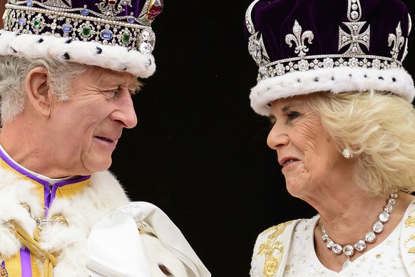 06.05.2023, Großbritannien, London: König Charles III. und Königin Camilla sehen sich an, als sie nach ihrer Krönung auf dem Balkon des Buckingham-Palastes stehen. Foto: Leon Neal/Pool Getty Images/AP ...