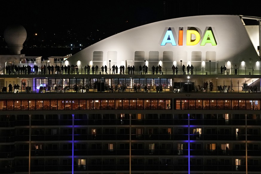 01.01.2022, Portugal, Lissabon: Menschen stehen auf dem Deck des deutschen Kreuzfahrtschiffs Aida Nova, das am Freitag, 31.12.2021, kurz vor Mitternacht in Lissabon angelegt hat. Knapp 3000 Kreuzfahre ...