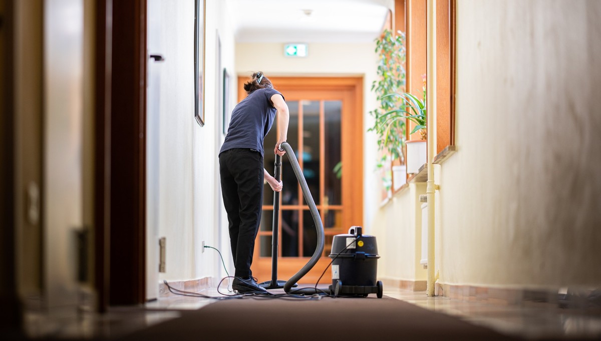 ARCHIV - 31.05.2021, ---: Eine Frau saugt in einem Hotel einen Flur. Besch