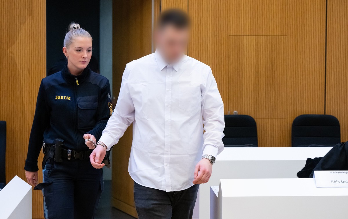 06.03.2023, Bayern, M�nchen: Einer von zwei wegen Mordes angeklagten M�nnern (r) wird vor Beginn der Verhandlung in den Hochsicherheitsgerichtssaal vom Landgericht M�nchen II gef�hrt. Im Prozess geht  ...