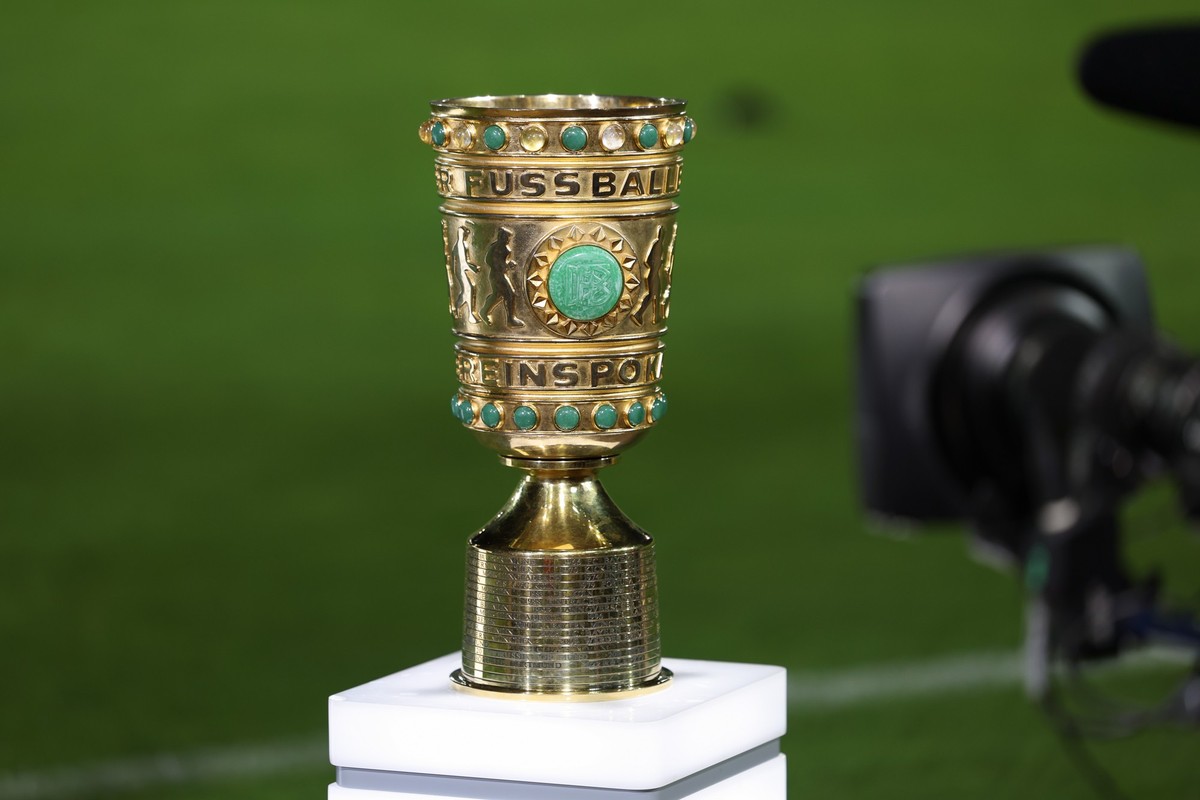 ARCHIV - 26.09.2023, Nordrhein-Westfalen, Münster: Fußball: DFB-Pokal, Preußen Münster - Bayern München, 1. Runde im Preußenstadion. Eine Abbildung des DFB-Pokals steht am Spielfeldrand mit einer TV-K ...