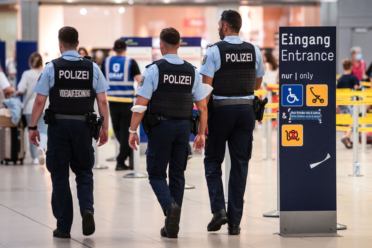 ARCHIV - 29.07.2022, Nordrhein-Westfalen, Köln: Beamte der Bundespolizei gehen an den Sicherheitskontrollen des Flughafens Köln/Bonn vorbei. (zu dpa: «Mutmaßliche Kindergeld-Betrügerin am Flughafen fe ...