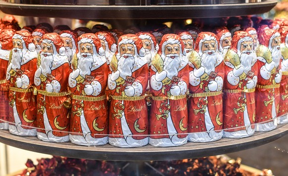 Schoko-Weihnachtsmaener stehen in einem weihnachtlich dekorierten Schaufenster in Freiburg. *** Schoko Weihnachtsmaener are standing in a christmas decorated shop window in Freiburg