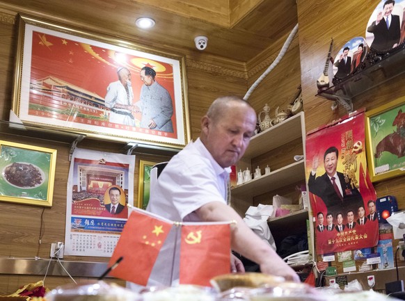 Xinjiang Uyghur Autonomous Region Photo taken on July 4, 2018, shows a man at a restaurant decorated with pictures of Chinese government leaders in Urumqi in the country s Xinjiang Uyghur Autonomous Region. PUBLICATIONxINxGERxSUIxAUTxHUNxONLY 