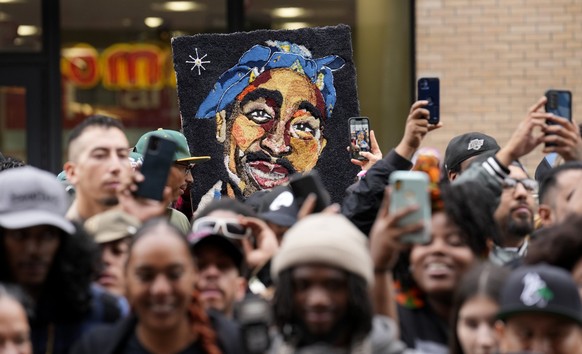An image of the late rapper and actor Tupac Shakur appears among fans during a ceremony honoring Shakur with a star on the Hollywood Walk of Fame on Wednesday, June 7, 2023, in Los Angeles. (AP Photo/ ...