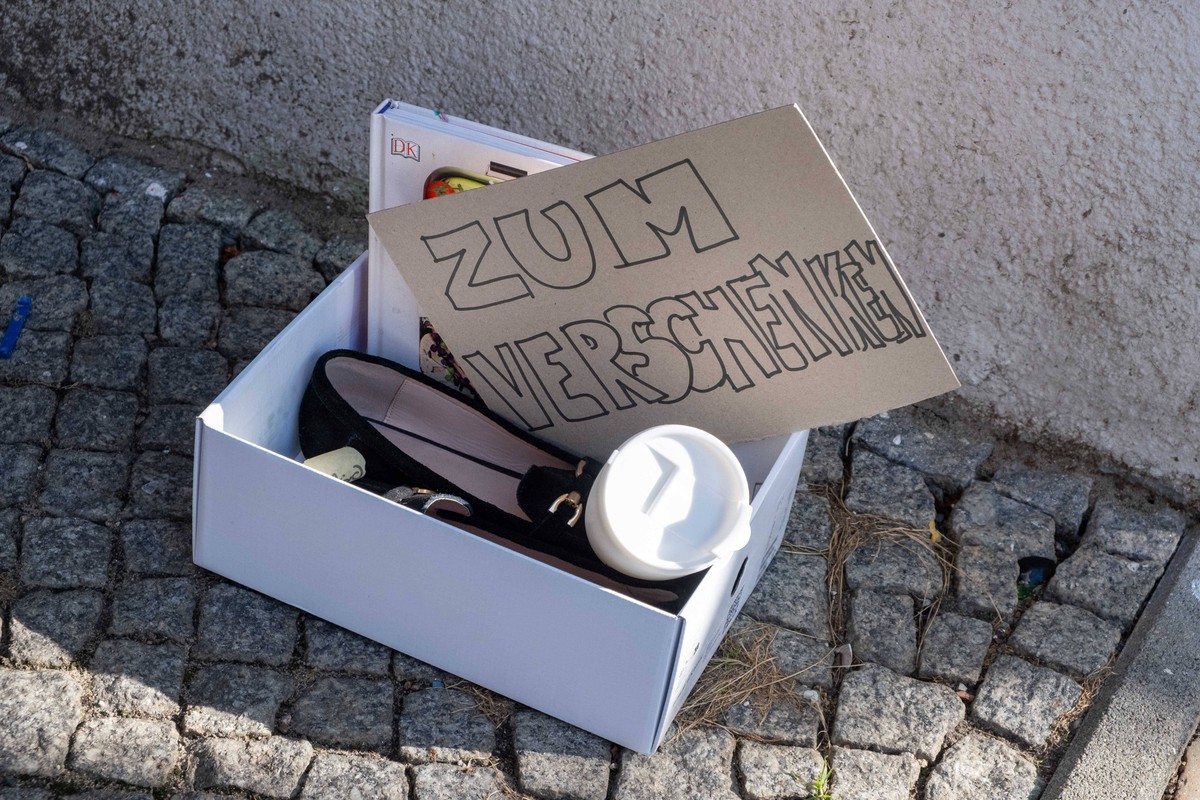 Zum verschenken - Eine Kiste mit ausgedienten dingen, eigenltich Müll, steht vor einem Hauseingang in Berlin. / To give away - A box of discarded things, actually garbage, stands in front of a house e ...