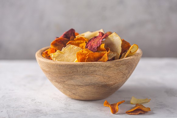Wooden bowl with organic vegetable dehydrated beet, carrot and potato chips