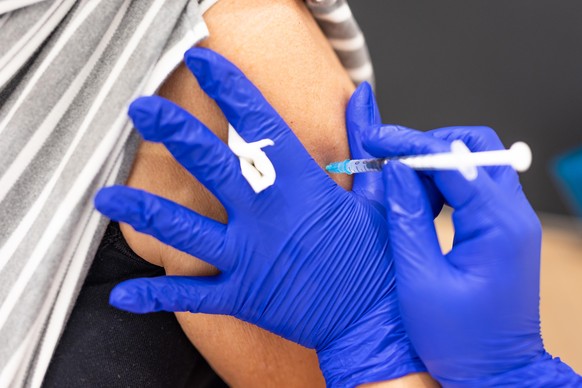 Die Mitarbeiterin eines Impfzentrums impft eine Frau mit dem Biontech-Impfstoff gegen Covid-19. Die Stadt will Menschen mit einer kostenlosen Bratwurst belohnen, die sich spontan im Impfzentrum gegen  ...