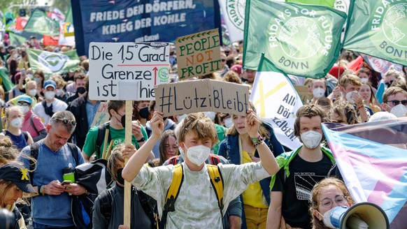 Teilnehmer einer Demonstration gehen auf einer Strasse in Richtung von Lützerath. &quot;Fridays for Future&quot;, &quot;Alle Dörfer Bleiben&quot; und andere Gruppen hatten zu der Kundgebung zum Schutz ...