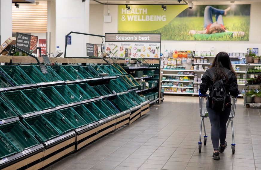 LONDON, UNITED KINGDOM - 2022/03/26: A customer seen with a trolley walking along the aisle of empty shelves of tomatoes. Lorry strikes in Spain continues affect the food supplies especially vegetable ...
