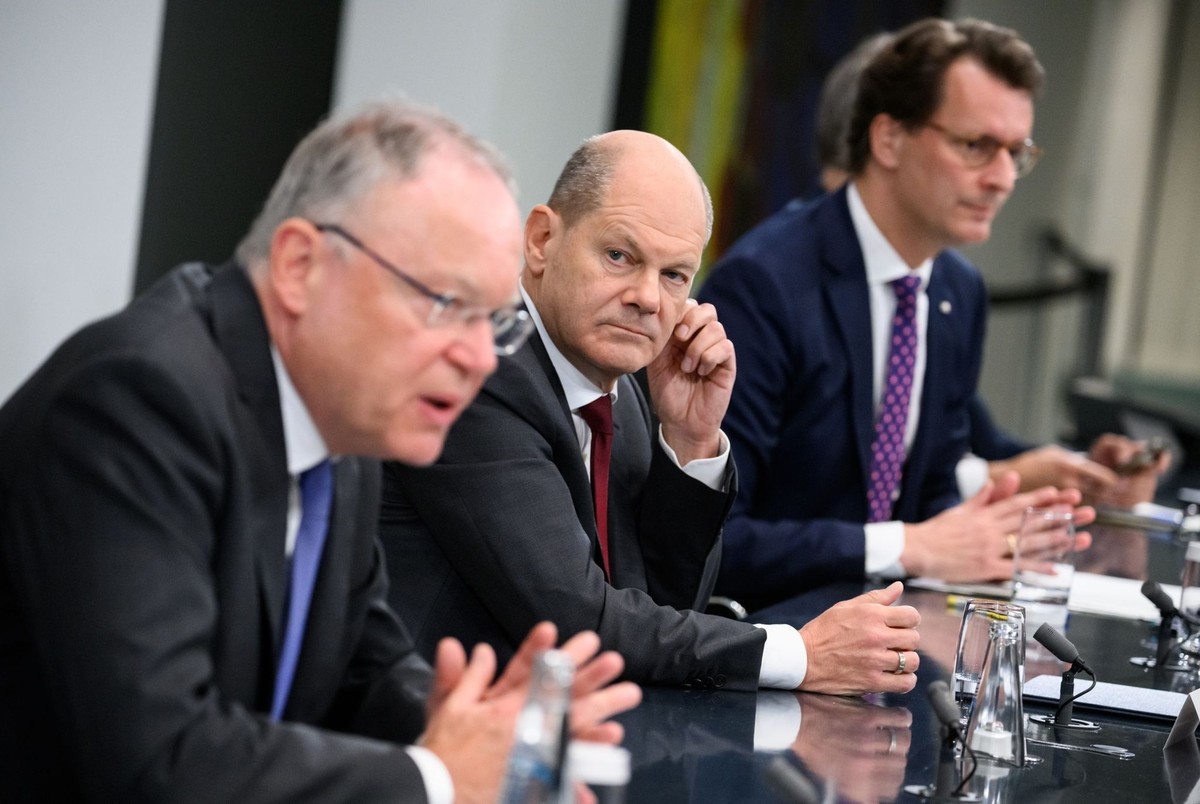 04.10.2022, Berlin: Bundeskanzler Olaf Scholz (M, SPD), Stephan Weil (l, SPD), Ministerpräsident von Niedersachsen, und Hendrik Wüst (r, CDU), Ministerpräsident von Nordrhein-Westfalen, äußern sich be ...