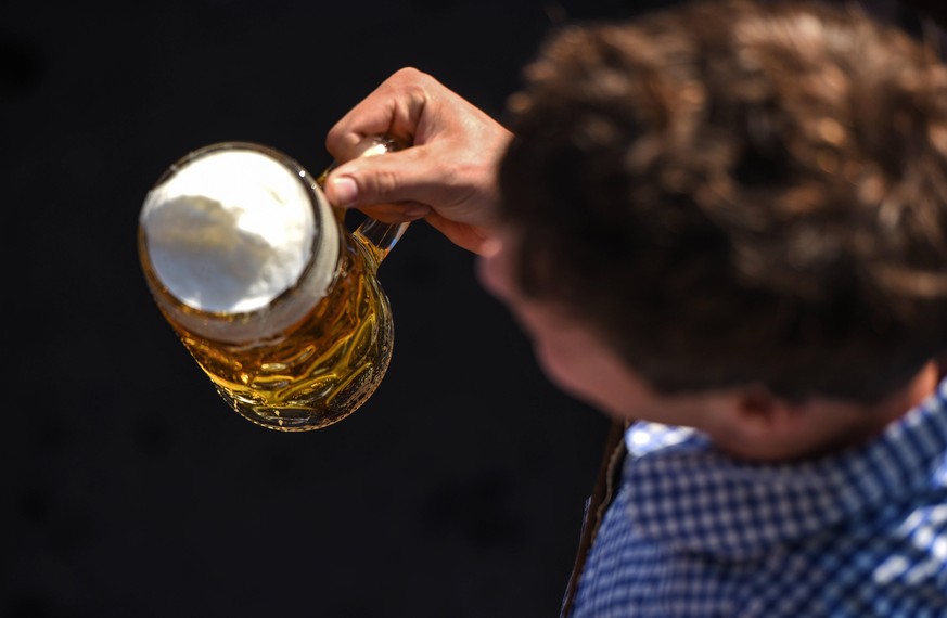 Themenbild Oktoberfest / Corona Ein Mann von oben alleine, mit bayrischer Tracht und einem Mass Bier. Der Untergrund ist tiefschwarz Themenbild Oktoberfest findet 2020 wg Corona nicht statt , M