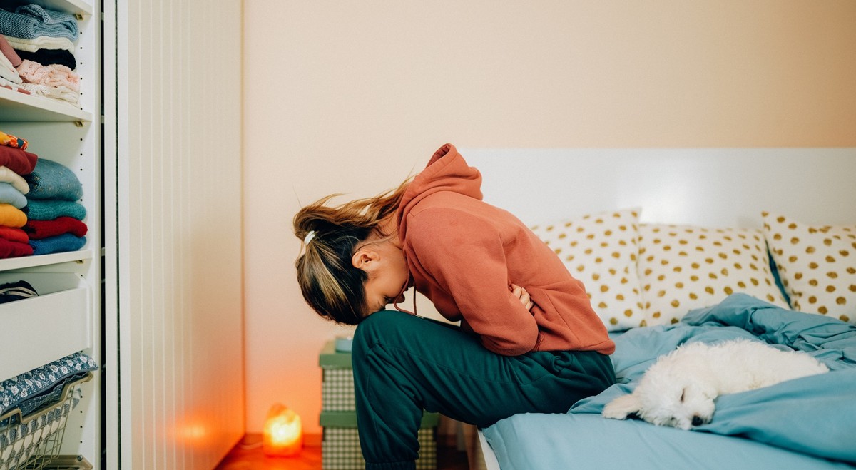 Young woman with painful menstruation resting in bed