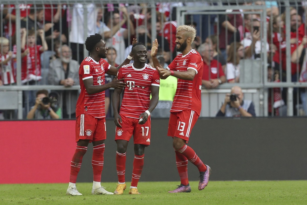 Bayern's Sadio Mane, centre celebrates with teammates Bayern's Alphonso Davies, left and Bayern's Eric Maxim Choupo-Moting, after scoring his sides third goal a rebound from his own sav ...