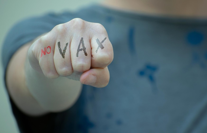 Anti vaccination concept. Woman fist with no vax written.