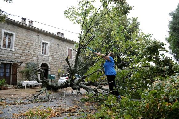 18.08.2022, Frankreich, Cognocoli-Monticchi: Eine Frau beginnt damit, einen Baum zu f�llen, der in Marato, auf der franz�sischen Mittelmeerinsel Korsika nach starken St�rmen umgest�rzt ist. Bei heftig ...