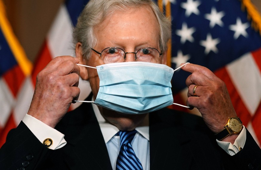 United States Senate Majority Leader Mitch McConnell Republican of Kentucky, puts on a mask after speaking during a press conference with other Republican leaders at the U.S. Capitol Building in Washi ...