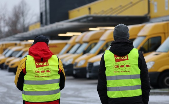 20.01.2023, Mecklenburg-Vorpommern, Rostock: Am Zustellst�tzpunkt der Deutschen Post DHL am Hauptbahnhof haben sich die Mitarbeiter zum Warnstreik eingefunden, im Hintergrund stehen die Zustellfahrzeu ...