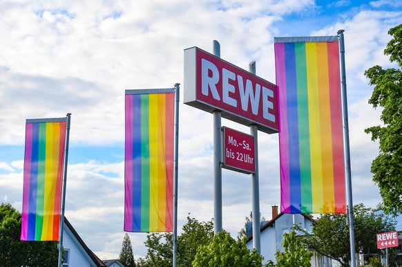 Regenbogenfahnen sind aufgezogen auf vor einer REW-Niederlassung nahe Wiesloch. REWE beendet die Kooperation mit dem DFB nach dem FIFA-Verbot der One-Love-Binde. Archivbild. Foto:Winfried Rothermel ** ...