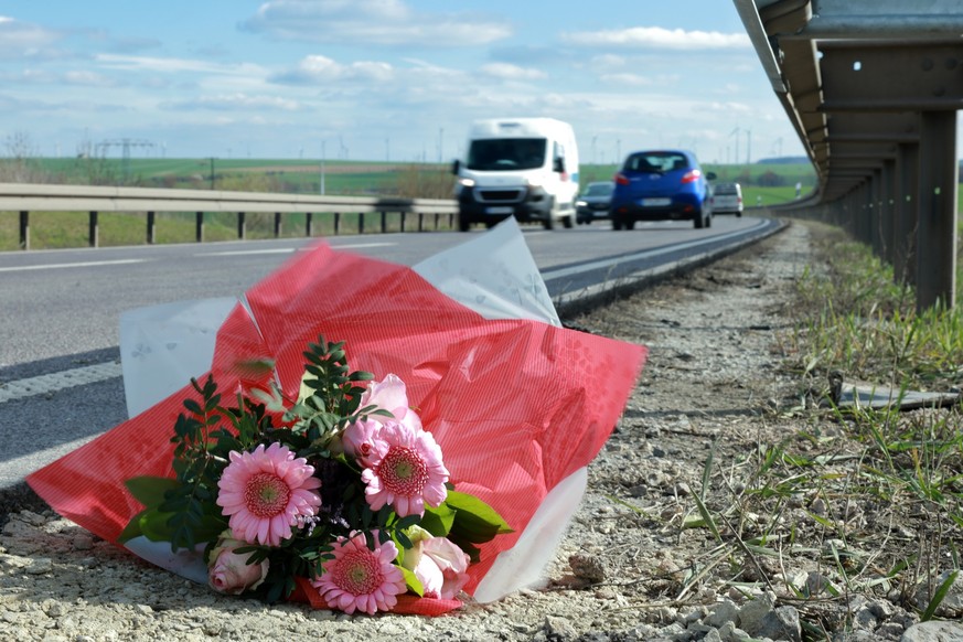 04.04.2023, Thüringen, Mühlhausen: Blumen liegen an der Unfallstelle an der Bundesstraße B247. Neue Wende bei den Ermittlungen zu dem schockierenden Unfall mit sieben Toten in Thüringen: Drei Tage nac ...