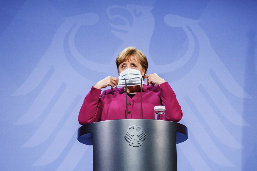 ARCHIV - 25.03.2021, Berlin: Bundeskanzlerin Angela Merkel (CDU) setzt nach einem Pressestatement ihre Maske auf. Das Bundeskabinett hat die