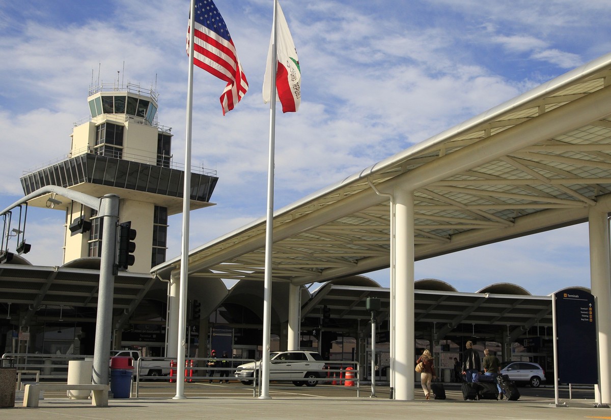 FILE - Travelers prepare to enter Oakland International airport Tuesday, Nov. 26, 2013, in Oakland, Calif. San Francisco has sued Oakland after officials there voted in favor of changing the name of t ...