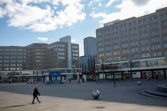 BERLIN, GERMANY - MARCH 21: Woman walks past almost empty Alexander Platz on March 21, 2020 in Berlin, Germany. Everyday life in Germany has become fundamentally altered as authorities tighten measure ...
