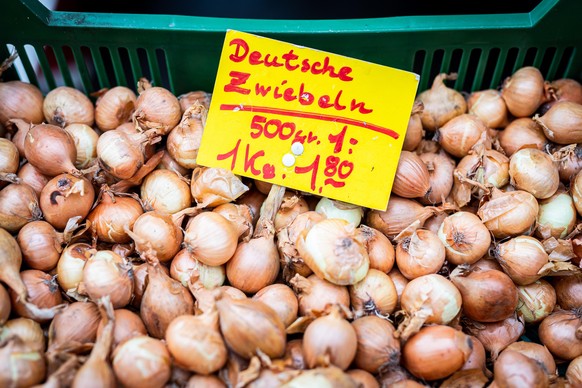 Deutsche Zwiebeln werden für 1,80 Euro pro Kilogramm (und für 1 Euro pro 500 Gramm) an einem Stand auf einem Wochenmarkt angeboten. Nach dem Preisschub im Jahr 2021 hoffen Verbraucher in Deutschland a ...