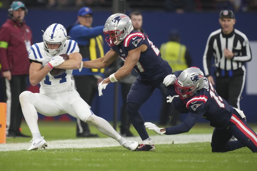 Indianapolis Colts wide receiver Alec Pierce (14) is stopped by New England Patriots cornerbacks Myles Bryant and Jack Jones, right, in the first half of an NFL football game in Frankfurt, Germany Sun ...