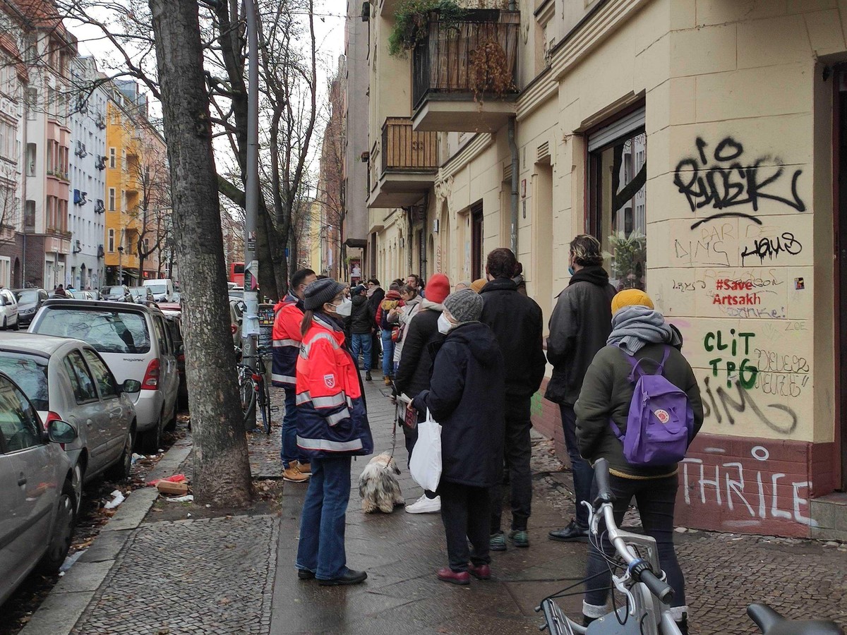 Das Ende der Schlange: Den Impfbus am Ende der Straße kann man nur noch als roten Punkt zwischen den Bäumen erkennen.