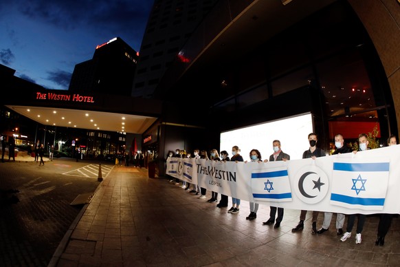 05.10.2021, Sachsen, Leipzig: Mitarbeiter des Hotel Westin, die mit einem Banner ein Zeichen gegen Antisemetismus setzen wollen. Nach Antisemitismus-Vorw�rfen haben sich am Abend Hunderte Menschen vor ...
