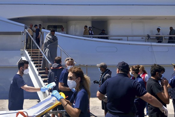14.06.2023, Griechenland, Kalamata: Flüchtlinge kommen nach einer Rettungsaktion in einem Hafen mit einer Yacht an. Es ist eines der schwersten Bootsunglücke in Griechenland seit Jahren. Einsatzkräfte ...