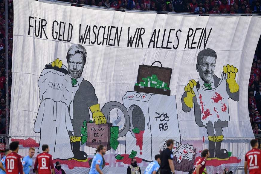 Bayern-Fans zeigen auf einem riesigen Plakat Vorstandsboss Oliver Kahn (l.) und Präsident Herbert Hainer und kritisieren die Zusammenarbeit mit "Qatar Airways". 