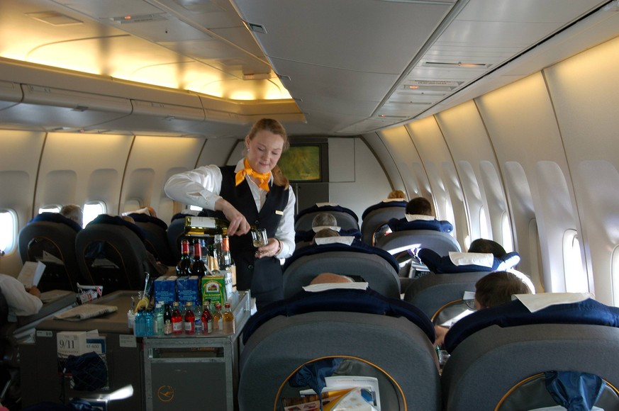 Lufthansa-Flugbegleiterin serviert den Passagieren der Business Class Getr