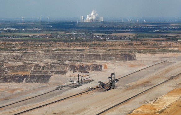 An aerial view of excavators in Hambach open-cast mine with RWE&#039;s brown coal power plant of Niederaussem in the backgroud, near the western German town of Kerpen-Buir west of Cologne, Germany, Oc ...