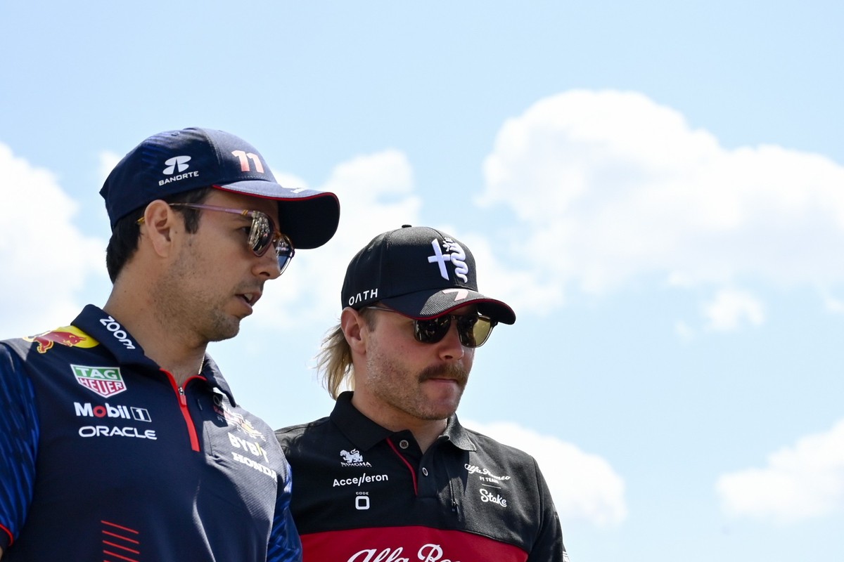 ARCHIV - 23.07.2023, Ungarn, Mogyorod: Motorsport: Formel-1-Weltmeisterschaft, Grand Prix von Ungarn, Rennen: Sergio Perez (l) aus Mexiko von Team Red Bull spricht mit Valtteri Bottas aus Finnland von ...