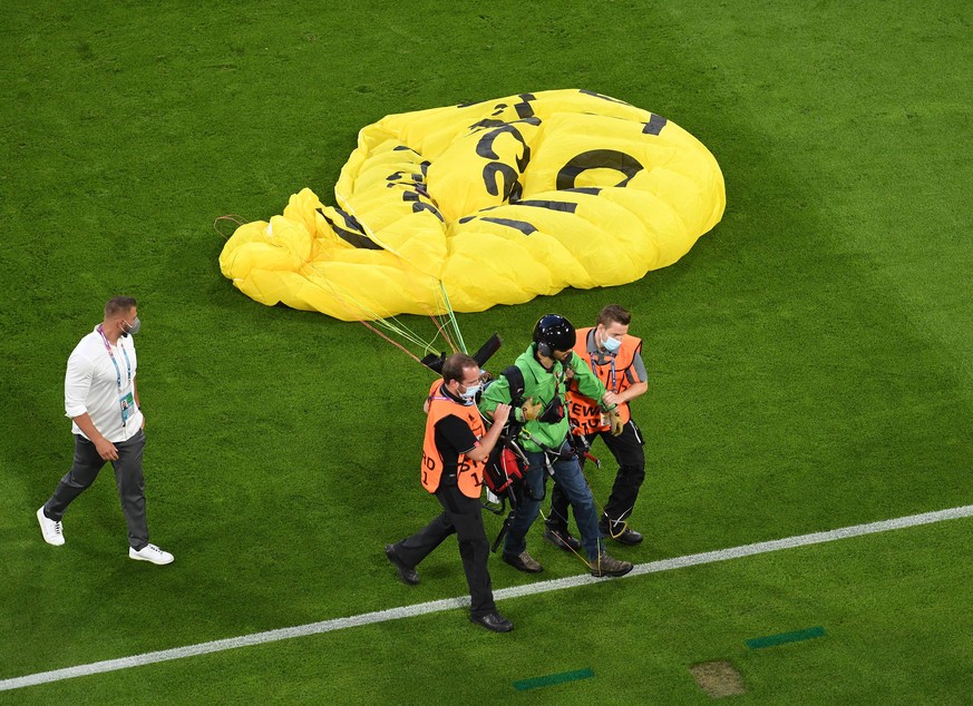 Nachdem der Pilot von Greenpeace auf das Fußballfeld abgestürzt war, wurde er abgeführt. 