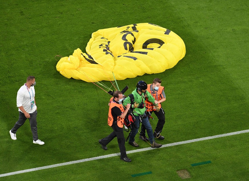 Nachdem der Pilot von Greenpeace auf das Fußballfeld abgestürzt war, wurde er abgeführt.