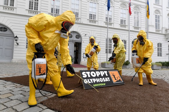 ARCHIV - 02.07.2019, �sterreich, Wien: Mitglieder der Umweltorganisation Greenpeace tragen gelbe Schutzanz�ge und Schutzmasken bei einer Protestaktion zum Thema Glyphosat vor Beginn einer Sitzung des  ...