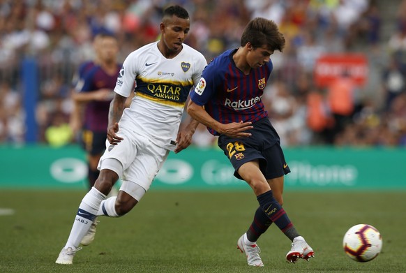 FC Barcelona&#039;s Riqui Puig, right, duels for the ball against Boca Juniors&#039; Sebastian Villa during the Joan Gamper trophy friendly soccer match between FC Barcelona and Boca Juniors at the Ca ...