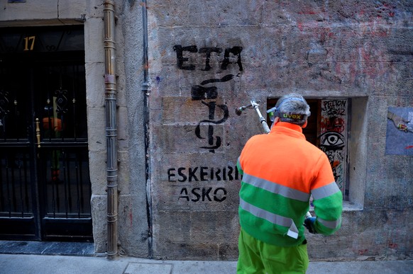 A municipal worker removes graffiti reading &quot;ETA, Thanks&quot; two days after militant Basque separatists ETA announced their dissolution, in Bilbao, Spain, May 5, 2018. REUTERS/Vincent West