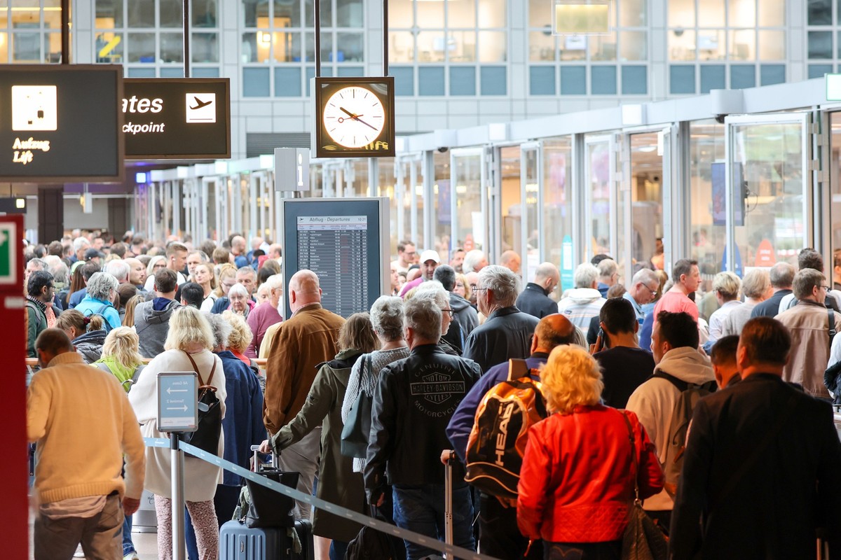 ARCHIV - 17.05.2023, Hamburg: Reisende warten in langen Schlangen vor der Sicherheitskontrolle am Flughafen Hamburg auf die Abfertigung. (zu dpa �Am Hamburger Flughafen soll Technik lange Warteschlang ...