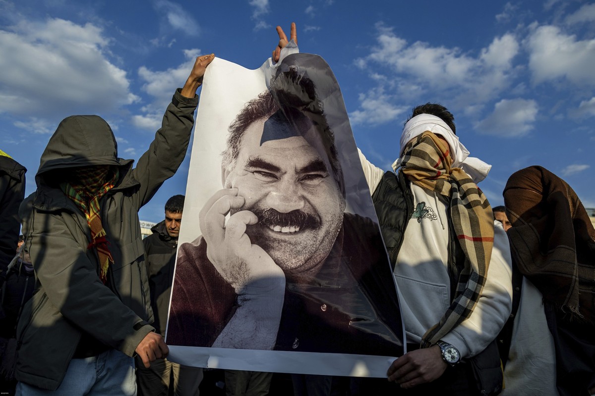 dpatopbilder - 27.02.2025, Türkei, Diyarbakir: Jugendliche halten ein Plakat des inhaftierten Anführers der Arbeiterpartei Kurdistans (PKK), Öcalan, während sie live auf einem Fernsehbildschirm mitver ...