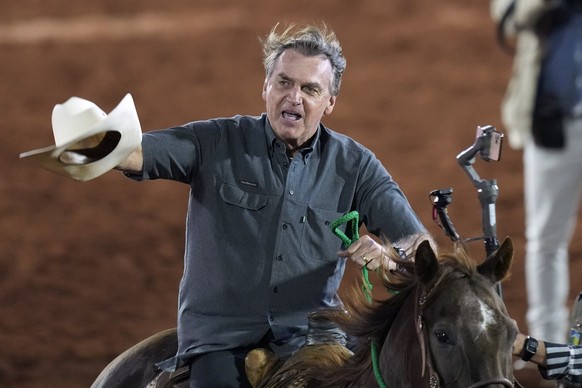 27.08.2022, Brasilien, Barretos: Jair Bolsonaro, Präsident von Brasilien, der für eine zweite Amtszeit kandidiert, reitet am 26. August 2022, auf einem Pferd beim internationalen Rodeo-Festival in Bar ...