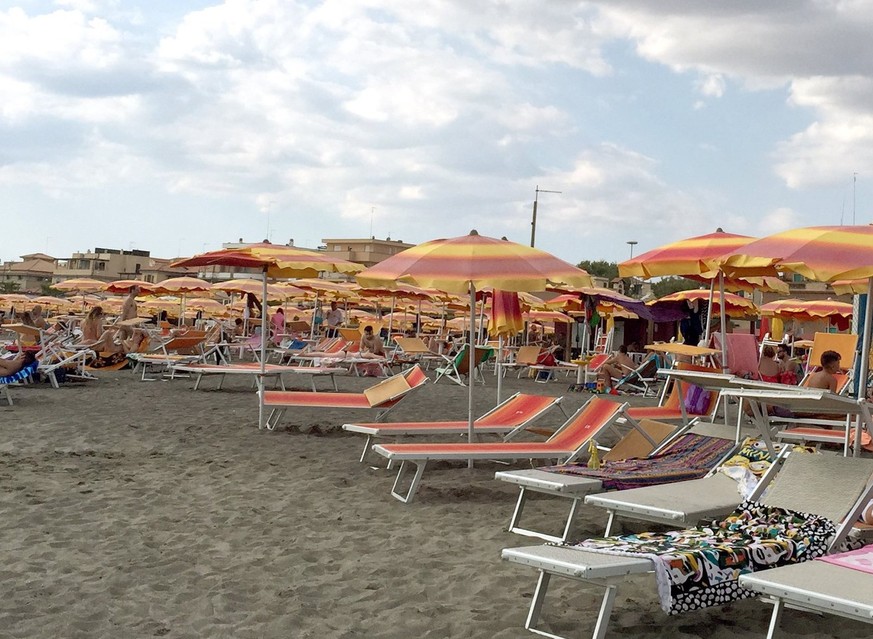 ARCHIV - 07.08.2016, Italien, Ostia: Sonnenliegen, zum Teil mit einem Handtuch belegt, stehen am Strand von Ostia in der N
