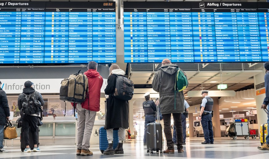 ARCHIV - 10.03.2023, Bayern, München-Flughafen: Passagiere informieren sich in der Abflughalle an einer Anzeigetafel. (zu dpa: «Wieder mehr Flugverkehr in Bayern - aber noch unter Vor-Corona-Niveau»)  ...