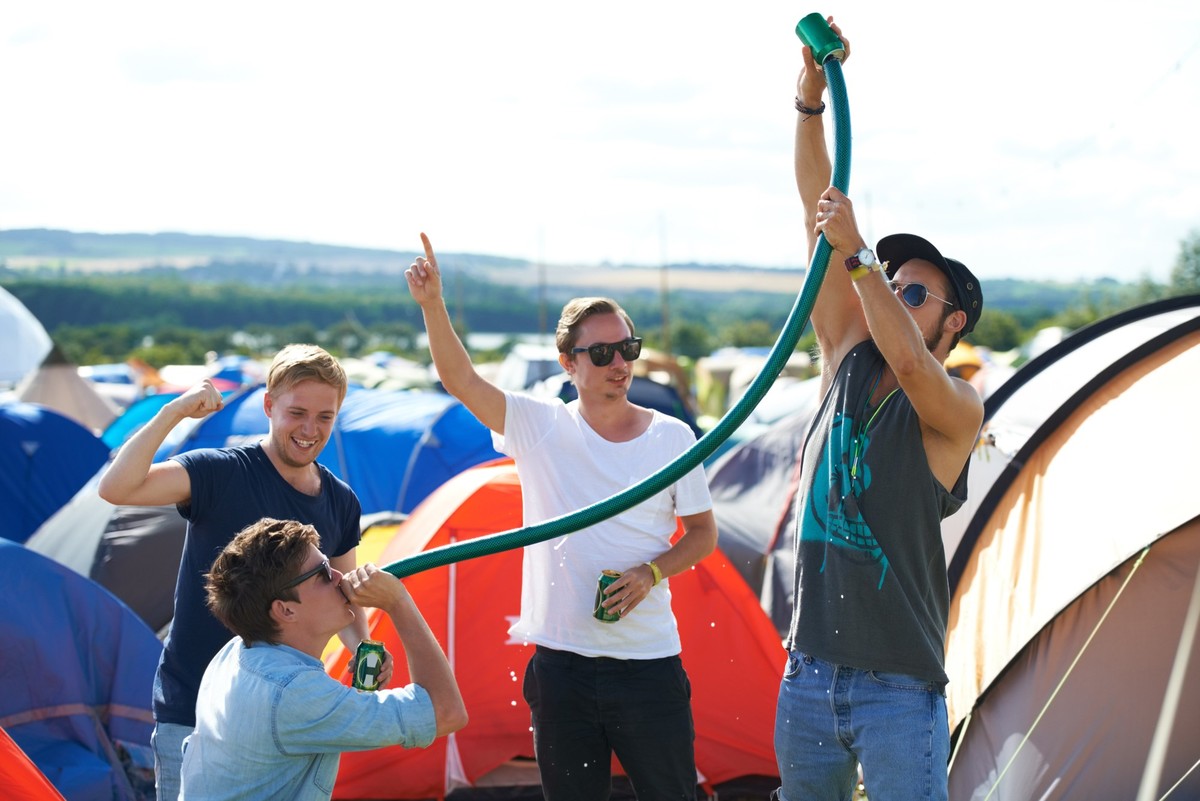 Alcohol, festival or drunk friends drinking together, beer beverage or outdoor social event. Summer music concert, party games celebration or excited people with freedom, hose funnel or pipe tube. Mod ...
