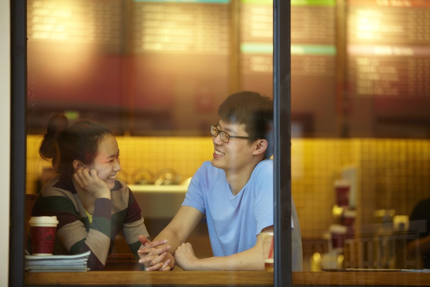 Young man and young woman dating in cafe