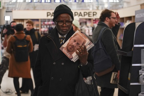 A customer holds copies of the new book by Prince Harry called &quot;Spare&quot; at a book store during a midnight opening in London, Tuesday, Jan. 10, 2023. Prince Harry's memoir “Spare” arrives in b ...